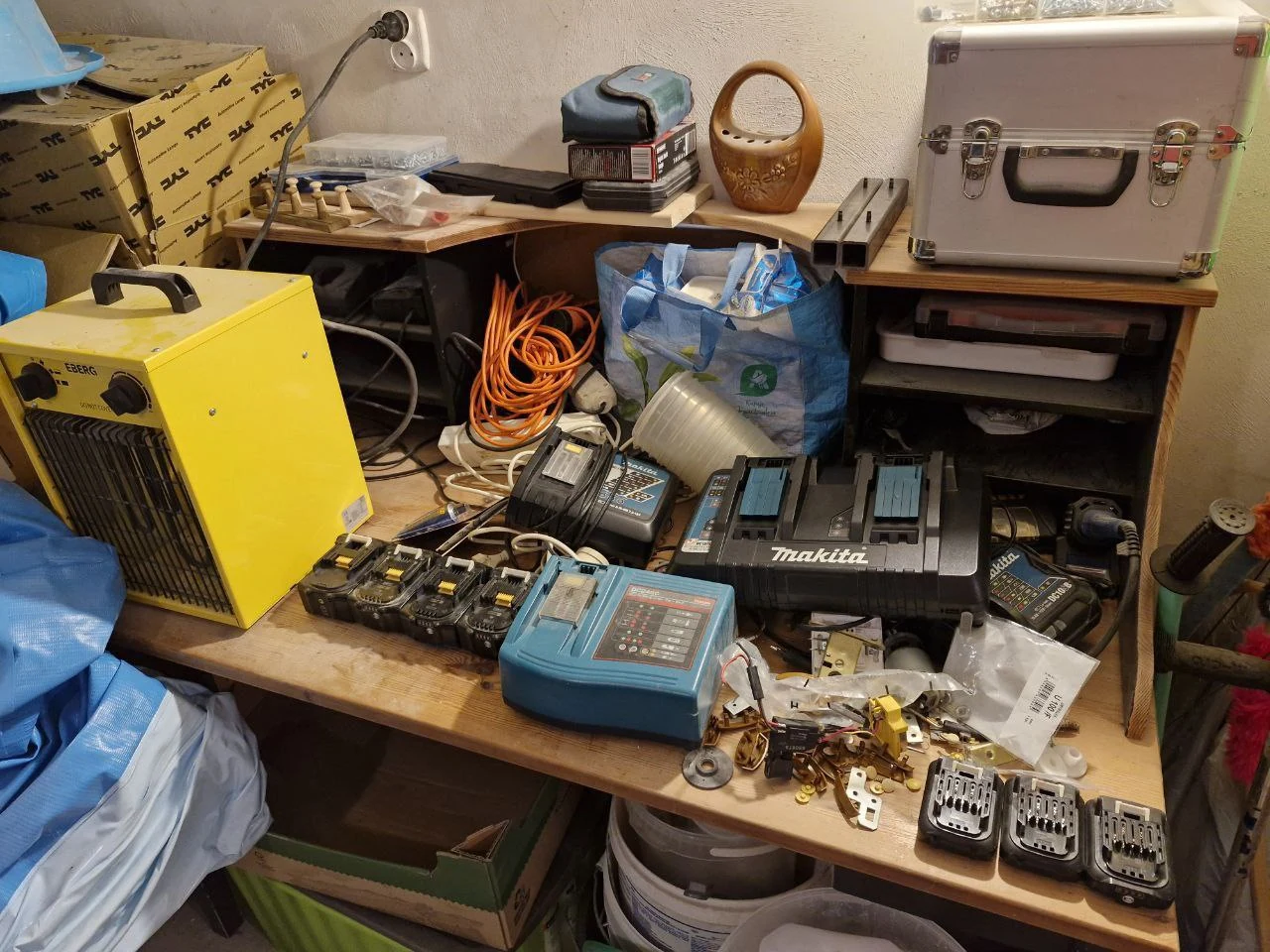 Stanowisko techniczne z narzędziami i częściami na półkach oraz blacie