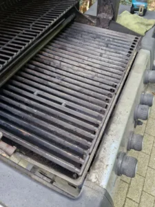 Komora grilla Broil King z głównym rusztem, górną półką i widocznymi osadami