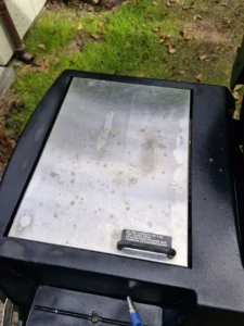 Zamknięta pokrywa bocznej kuchenki z etykietą ostrzegawczą