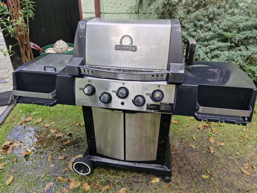 Pełny widok grilla Broil King SIGNET z bocznymi półkami i dolną szafką