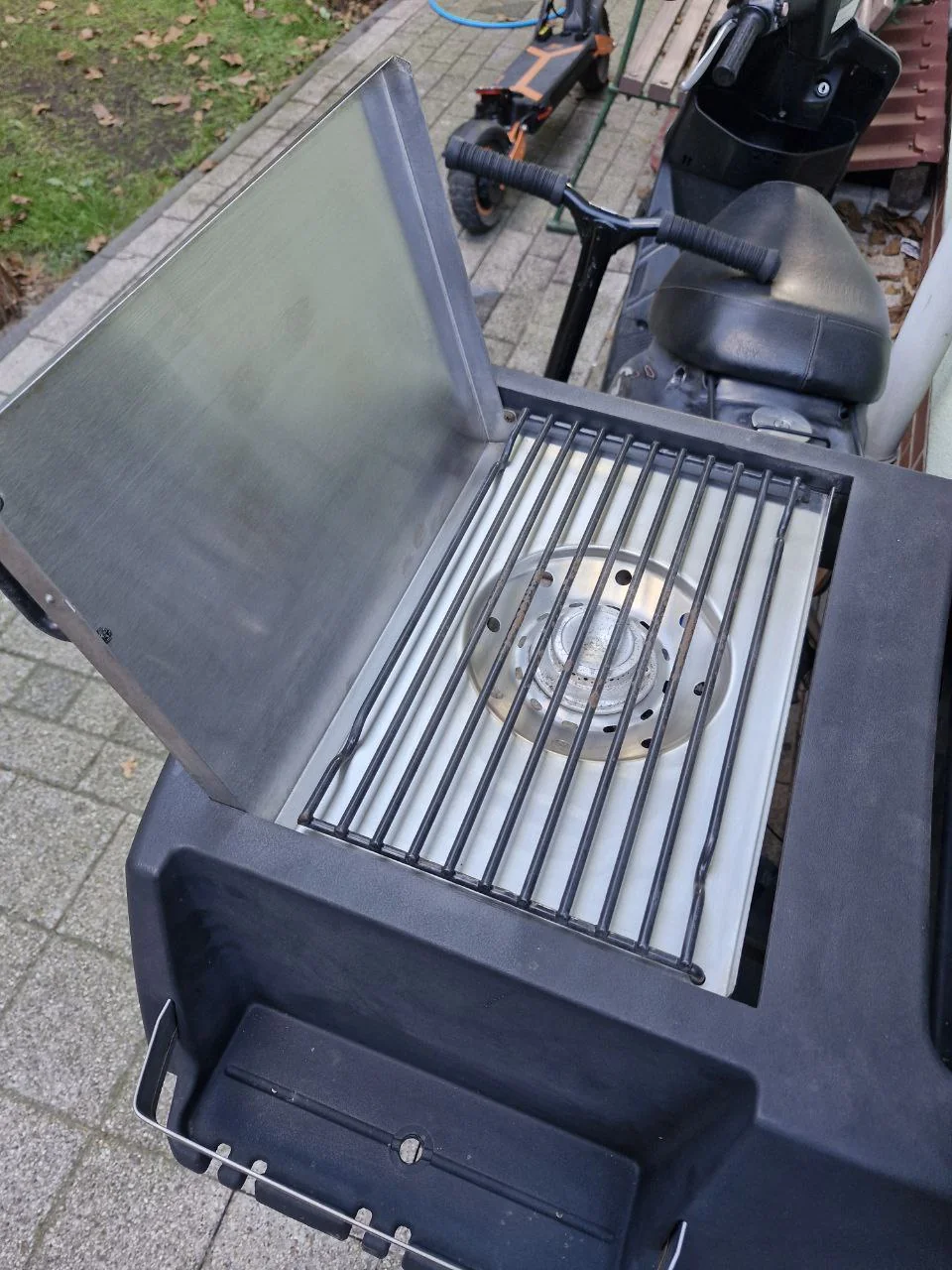 Otwarta boczna kuchenka grilla z rusztem nad palnikiem, sesja A05